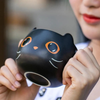 Mug chat noir tenu en main, vu de dessous